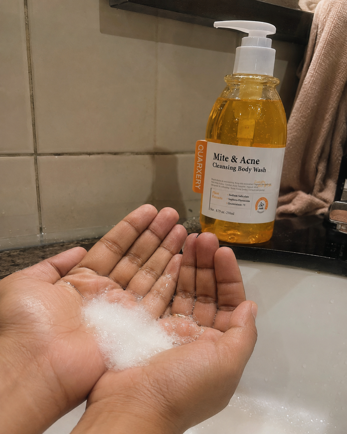Espuma del gel corporal Quarxery entre las manos
